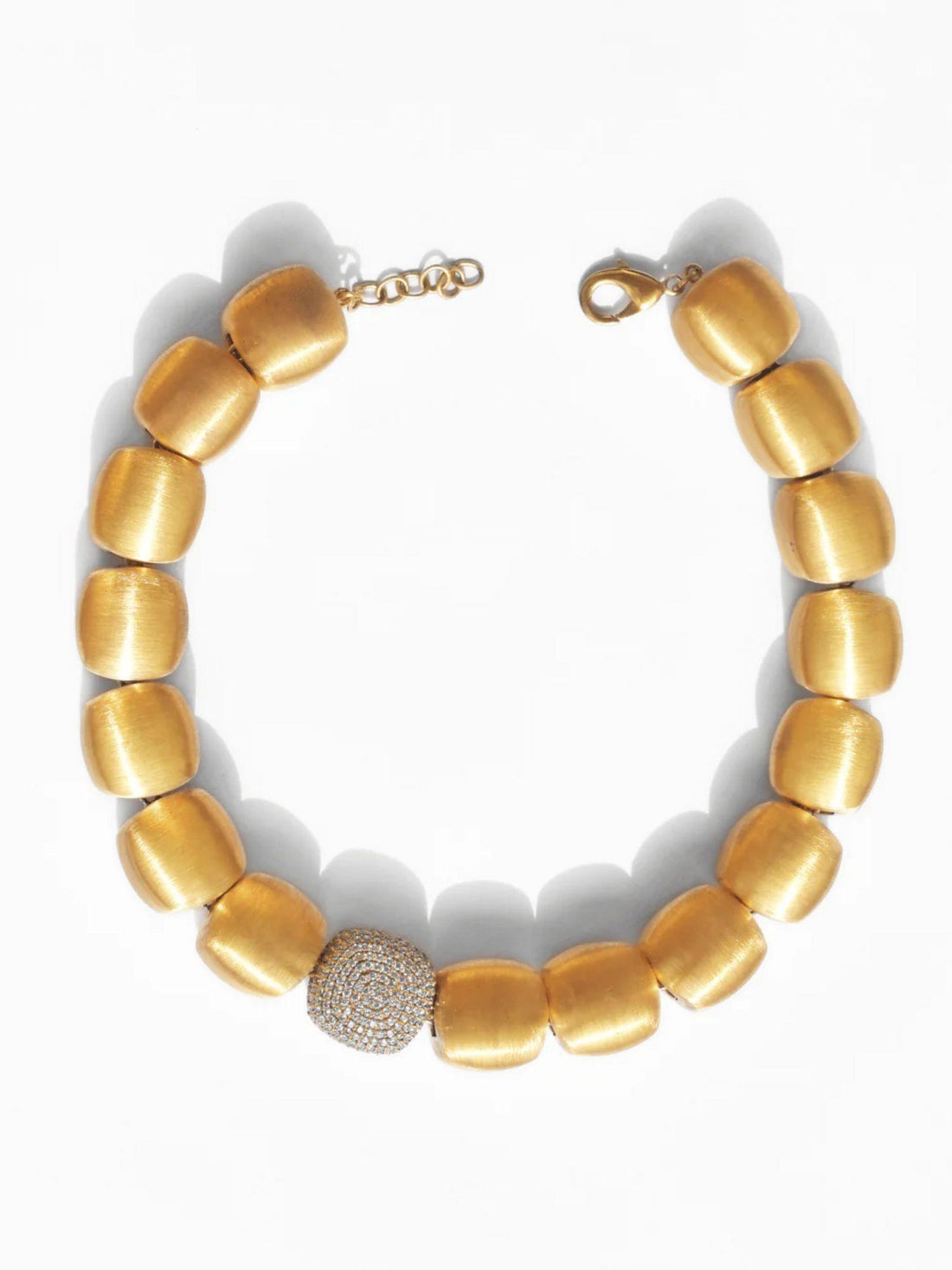 Model wearing brushed gold cube necklace styled with embroidered top