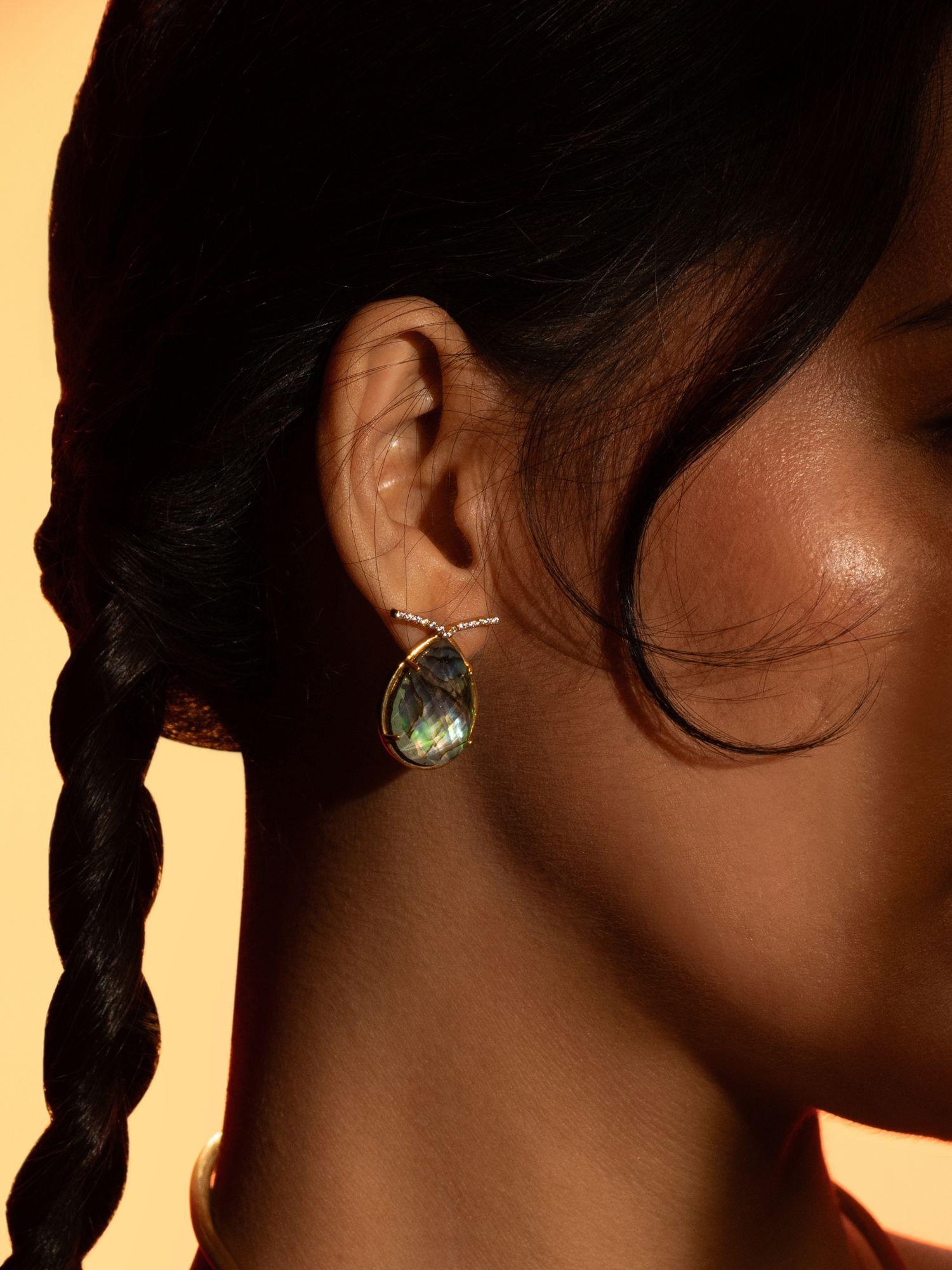 Aeris abalone labradorite teardrop earring worn in profile close-up against warm golden background.