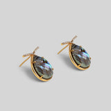 Angled product shot of Aeris abalone teardrop earrings showing stone iridescence and gold setting detail.