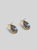 Angled product shot of Aeris abalone teardrop earrings showing stone iridescence and gold setting detail.