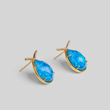 Aeris teardrop earrings with vivid blue opal crystal haze stone and gold zircon bar on neutral background.
