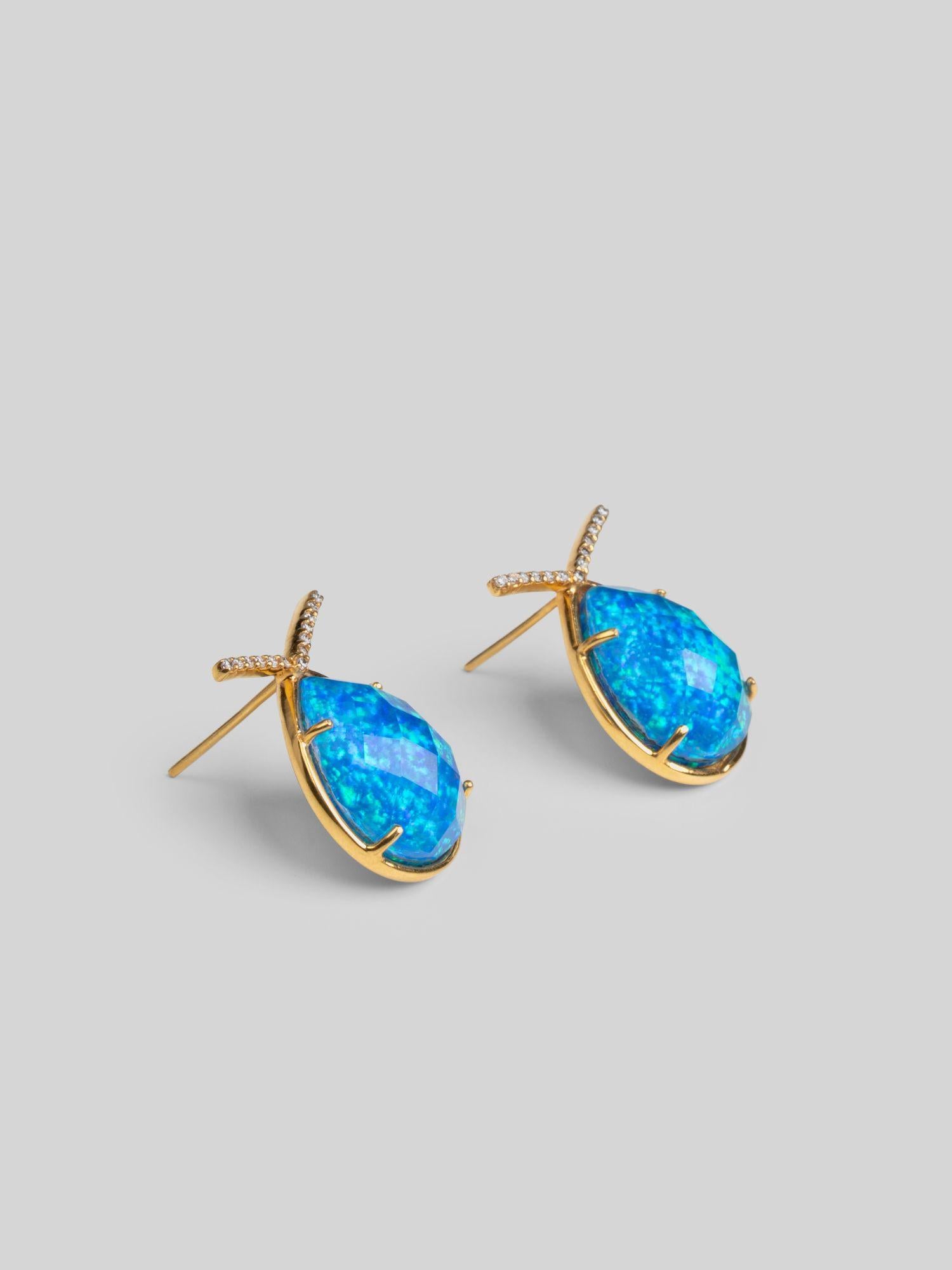Aeris teardrop earrings with vivid blue opal crystal haze stone and gold zircon bar on neutral background.