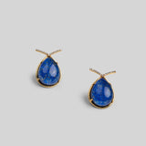 Angled product shot of Aeris deep blue teardrop earrings showing stone texture and gold setting.