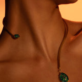 Aeris green opal pendant on open gold bar necklace worn close to neck in warm editorial light