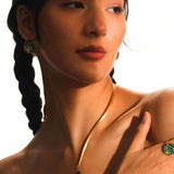 Model wearing Aeris opal pendant necklace and matching earrings in a warm editorial portrait.