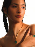 Model wearing Aeris opal pendant necklace and matching earrings in a warm editorial portrait.