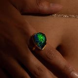Aeris opal crystal haze cocktail ring worn on hand in close moody warm editorial shot.