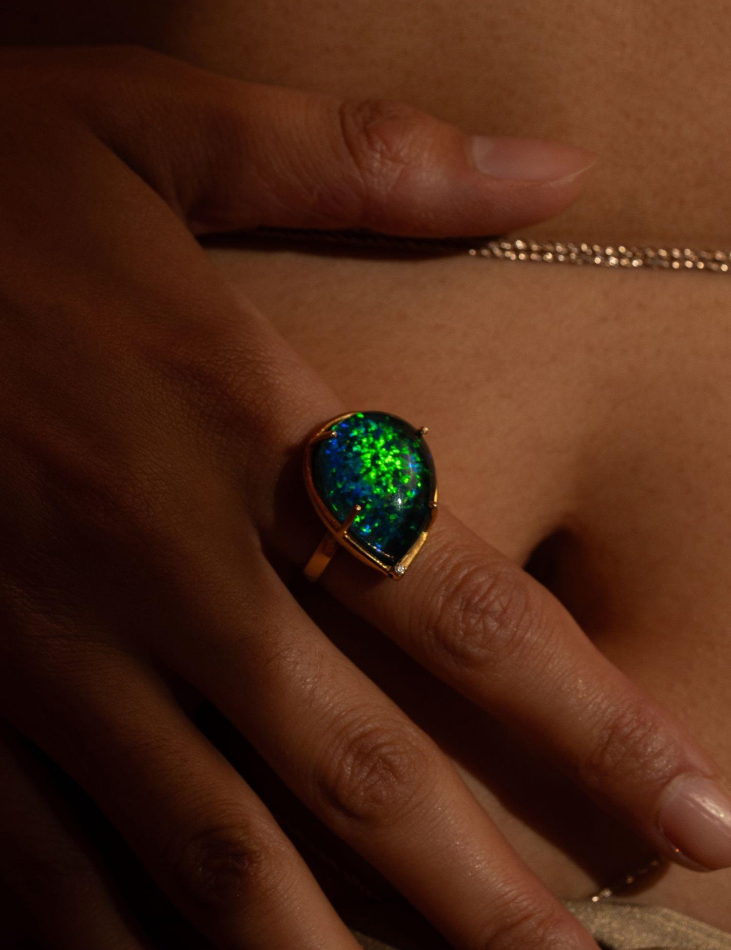 Aeris opal crystal haze cocktail ring worn on hand in close moody warm editorial shot.