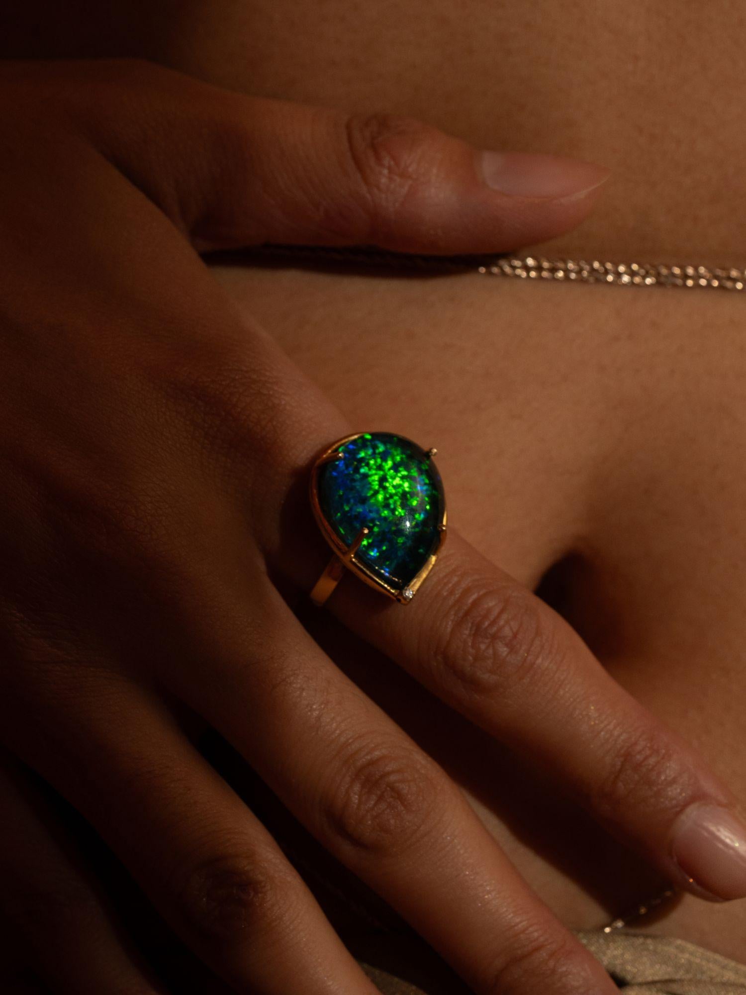 Aeris opal crystal haze cocktail ring worn on hand in close moody warm editorial shot.