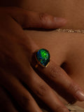 Aeris opal crystal haze cocktail ring worn on hand in close moody warm editorial shot.