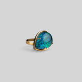 Three-quarter product shot of Aeris green opal cocktail ring in 24k gold on neutral background.