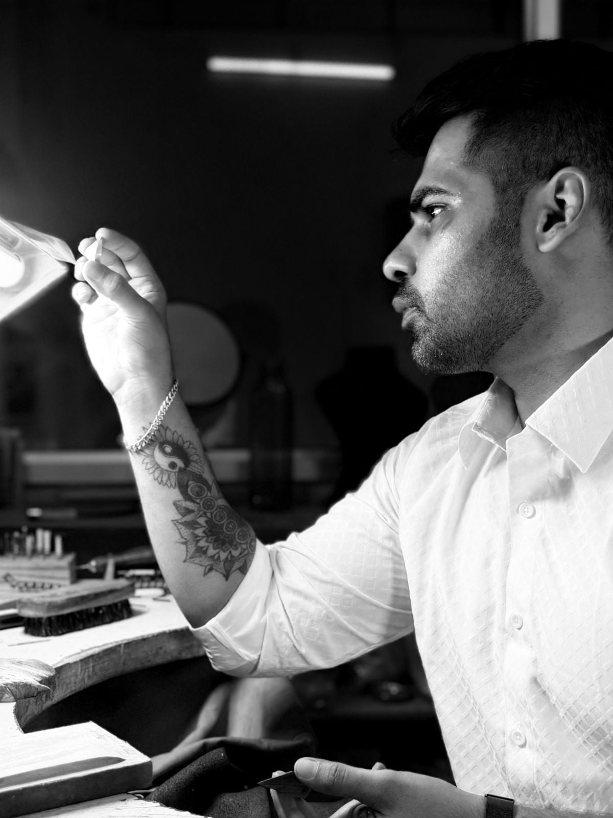 Man holding a small object in a workshop setting