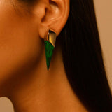 Side profile of model wearing malachite spike earring, warm golden light