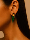 Side profile of model wearing malachite spike earring, warm golden light