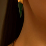 Close-up of malachite spike earring on ear with gold collar necklace visible