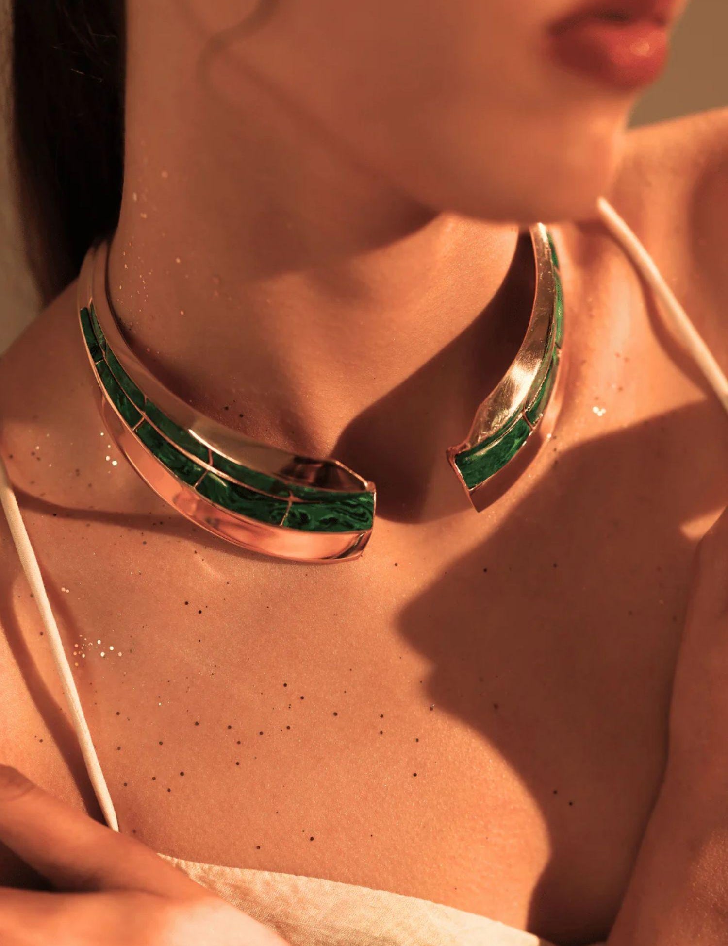 Model wearing malachite inlay gold collar necklace with mirror finish on bare skin