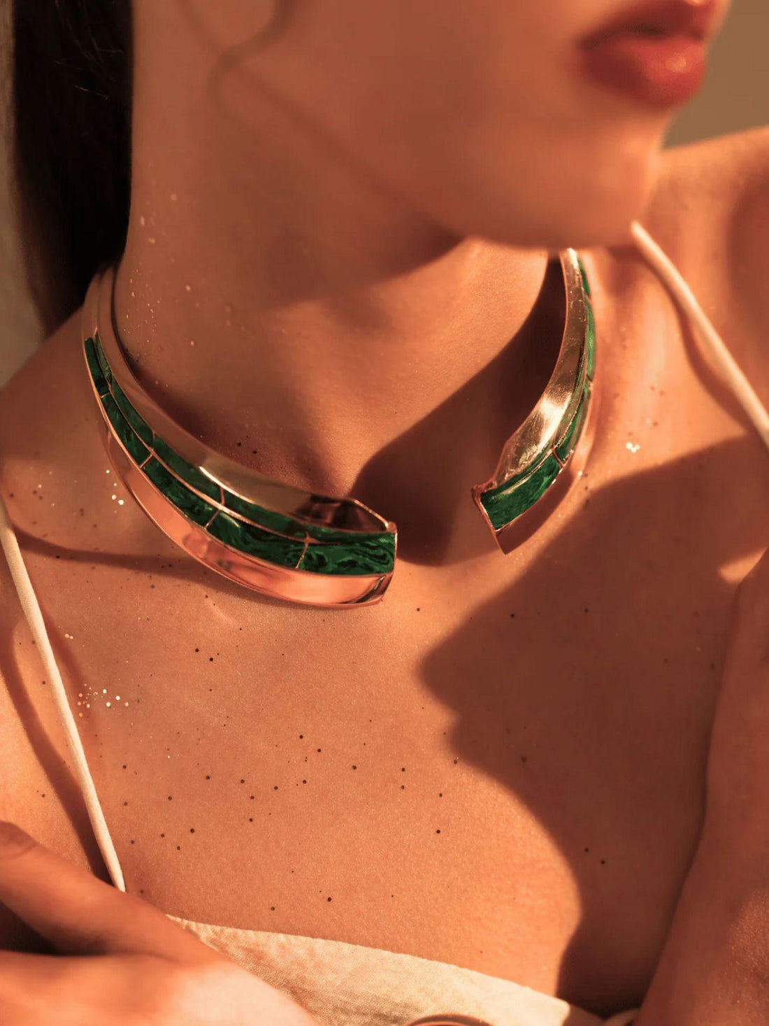 Model wearing malachite inlay gold collar necklace with mirror finish on bare skin