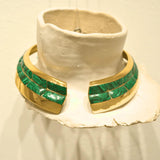 Malachite and gold collar necklace displayed on white clay prop