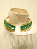 Malachite and gold collar necklace displayed on white clay prop