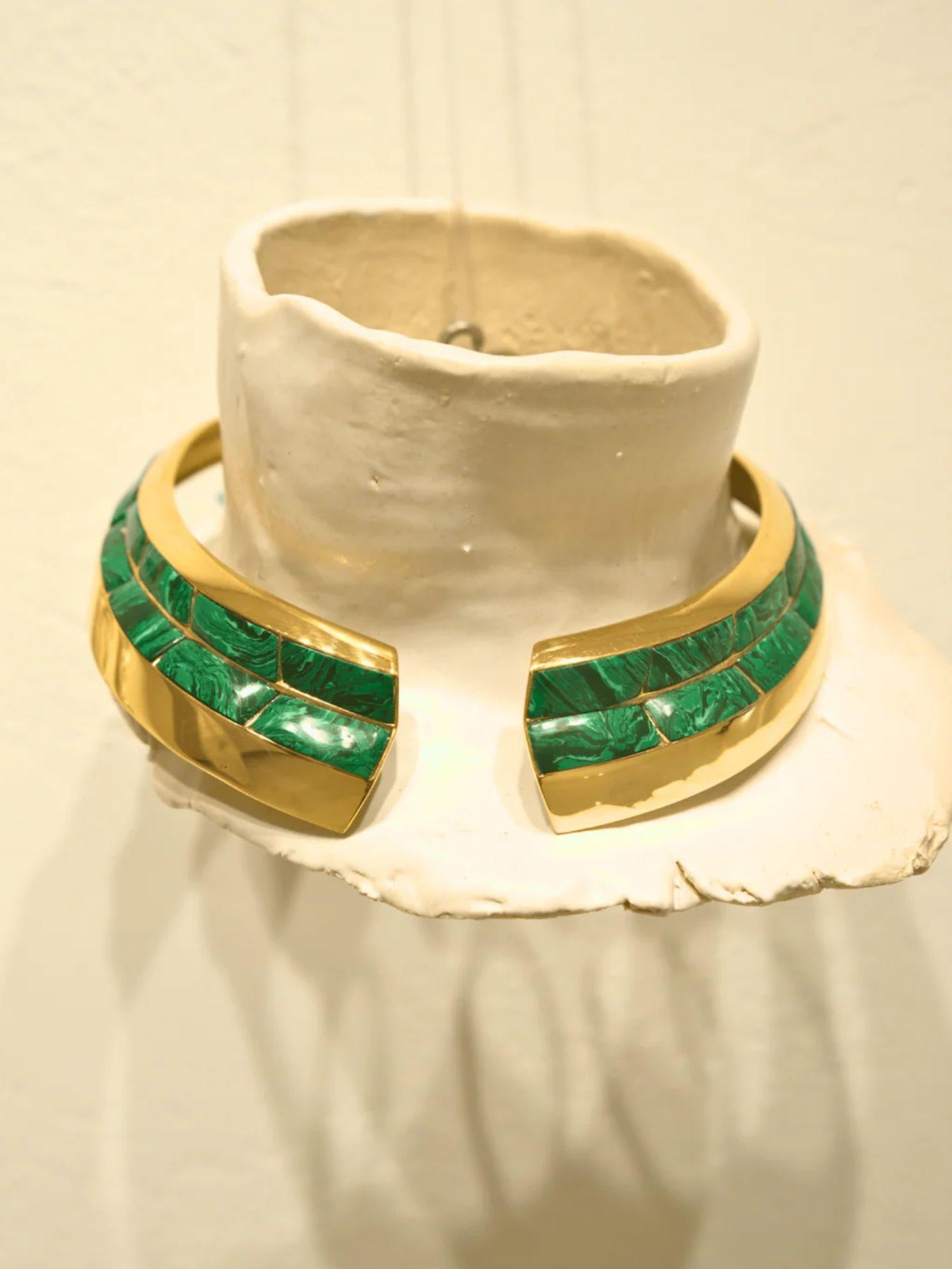 Malachite and gold collar necklace displayed on white clay prop