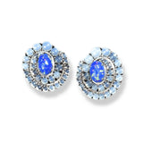 Pair of blue fire opal and moonstone spiral stud earrings on white background