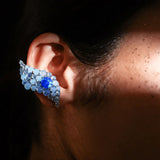 Side profile of model wearing blue opal wave ear cuff in low natural light