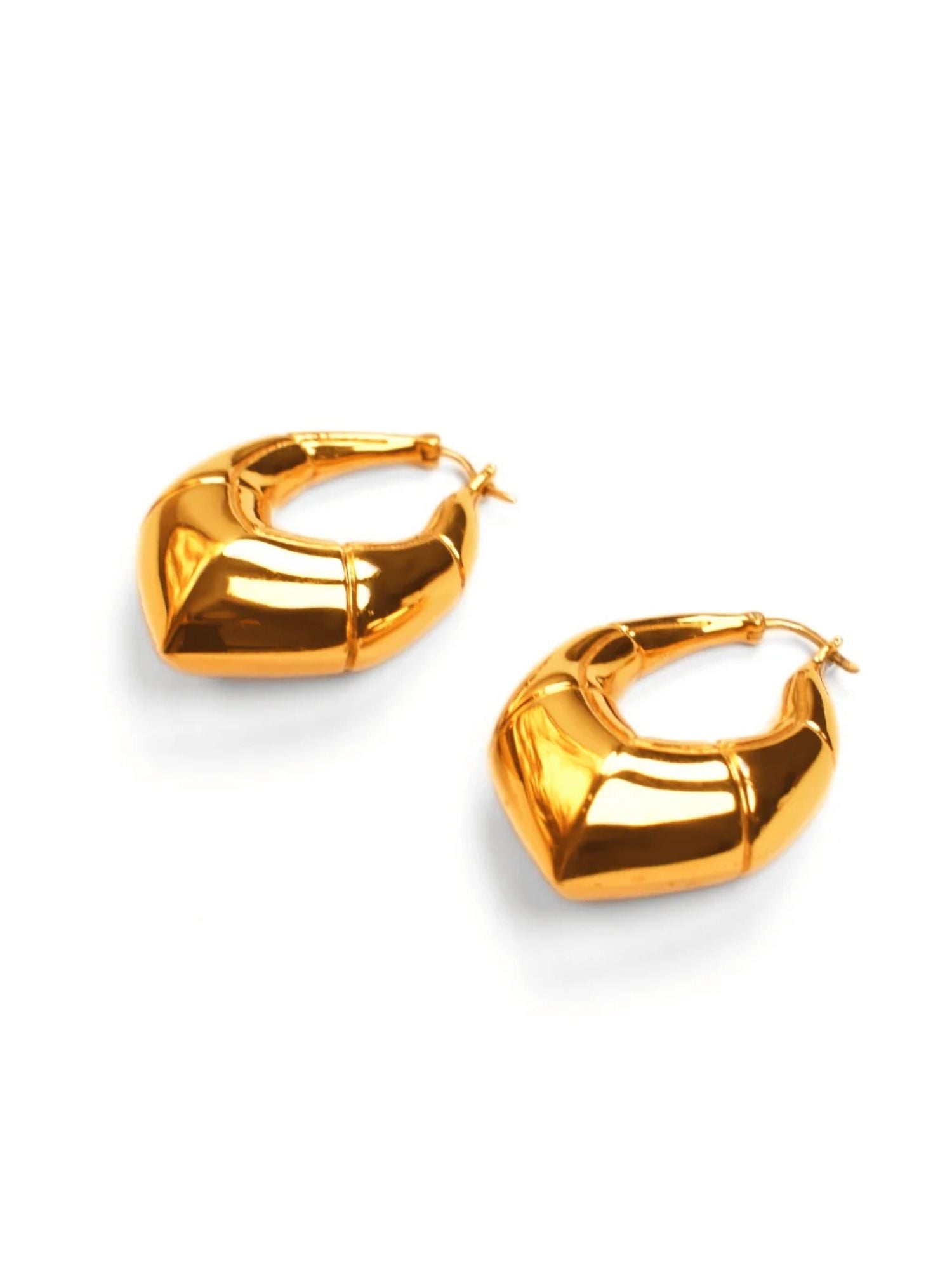 Two large gold claw earrings showing angular geometric form on white