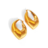 Flat lay of large gold claw hoop earrings showing brushed surface detail