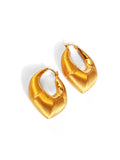 Flat lay of large gold claw hoop earrings showing brushed surface detail
