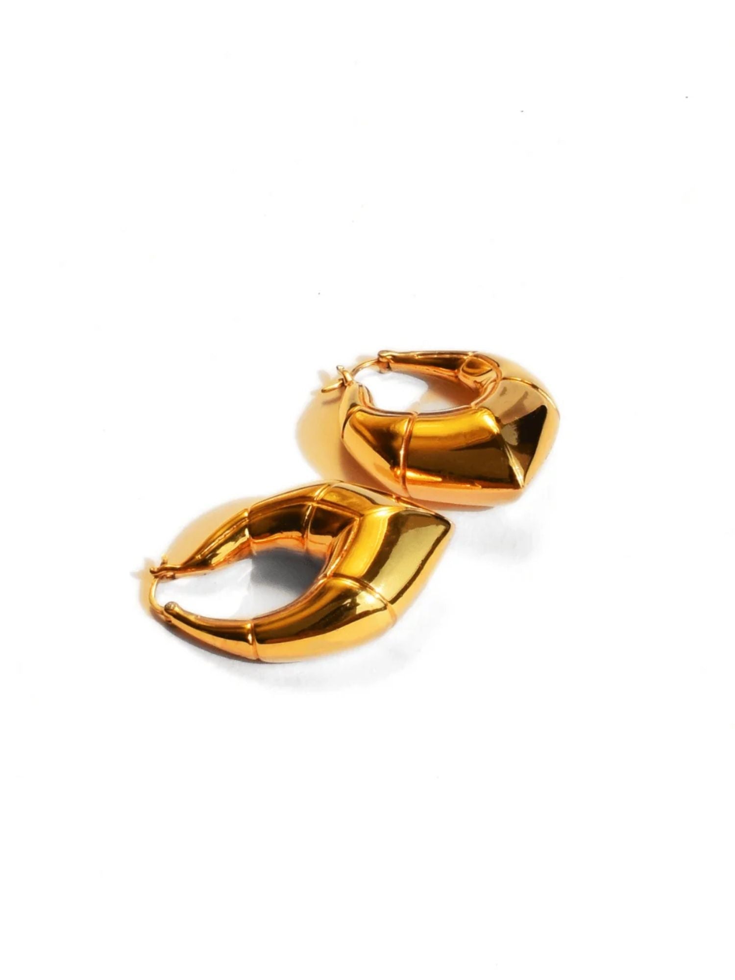 Small gold and silver claw earrings with cone stud showing size comparison