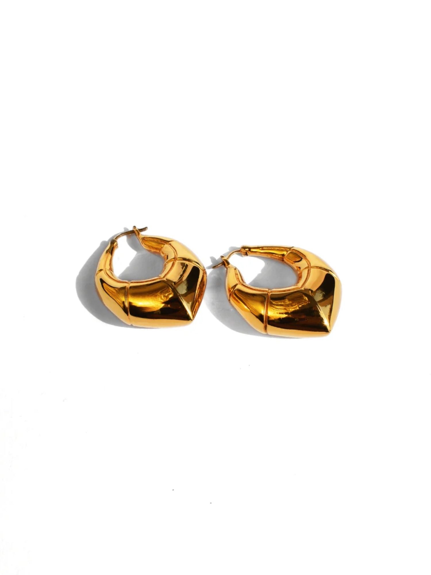Small gold claw hoop earrings showing angular form on white background