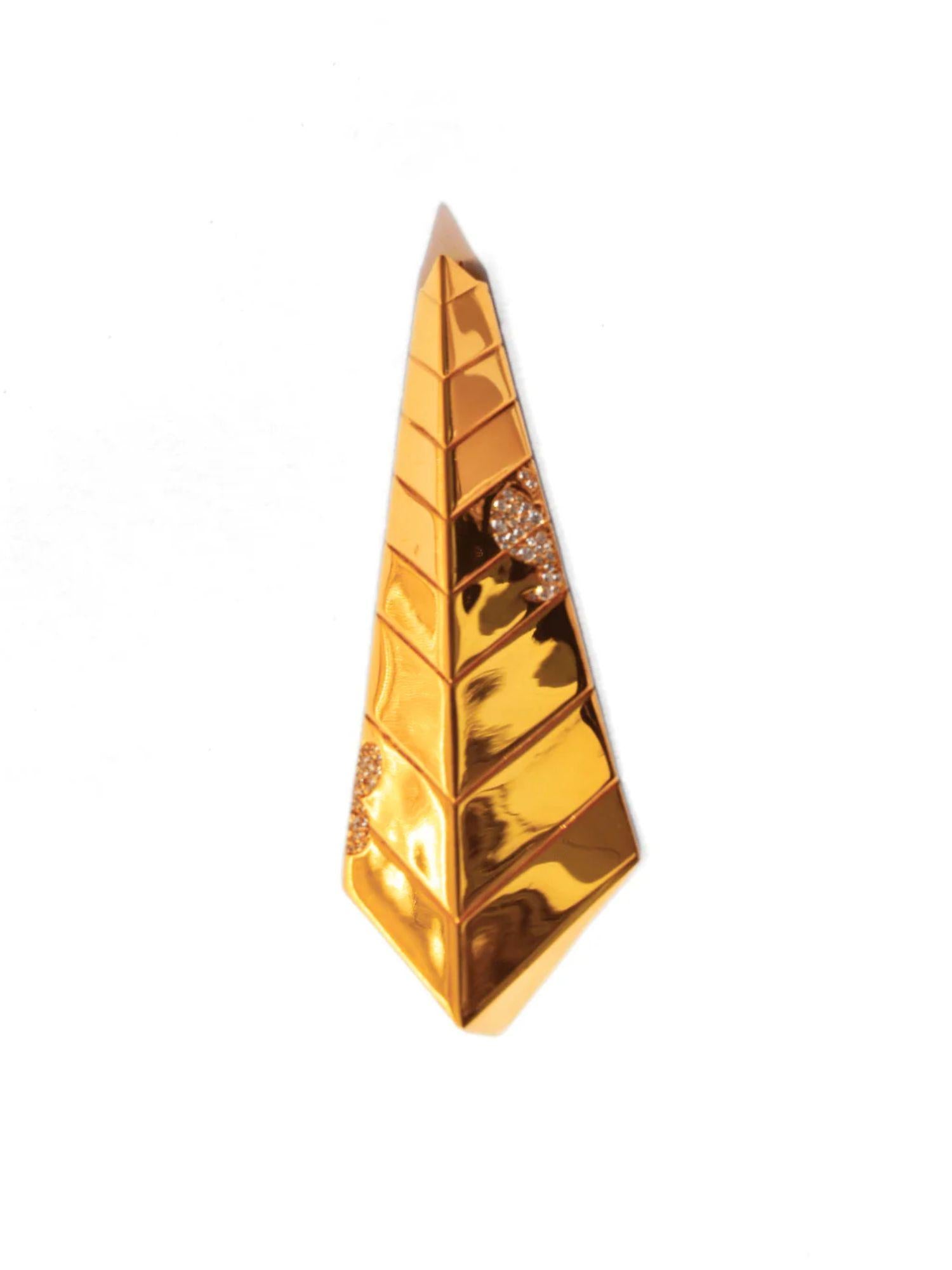 Close-up of triangular gold tie pendant with CZ stone inlay