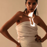 Full-body model shot in white dress wearing gold collar necklace with tie pendant