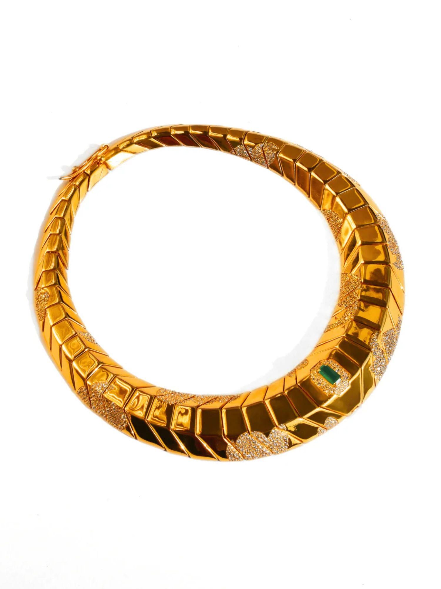 Front-facing product shot of sculptural gold collar necklace with tie pendant