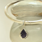 Silver bangle choker with raw agate teardrop charm resting on clay prop