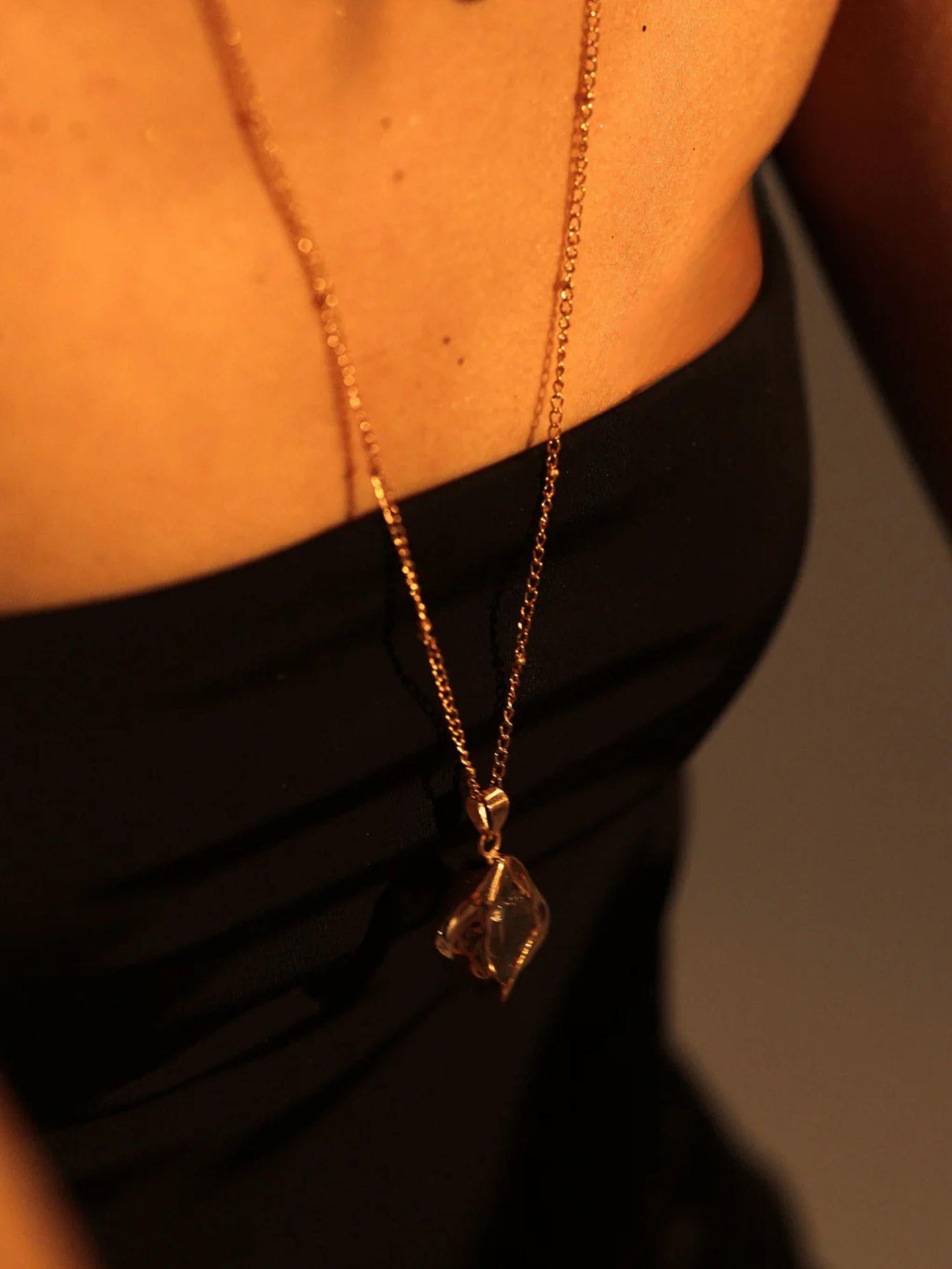 Model wearing raw citrine gold pendant necklace, black top collarbone shot