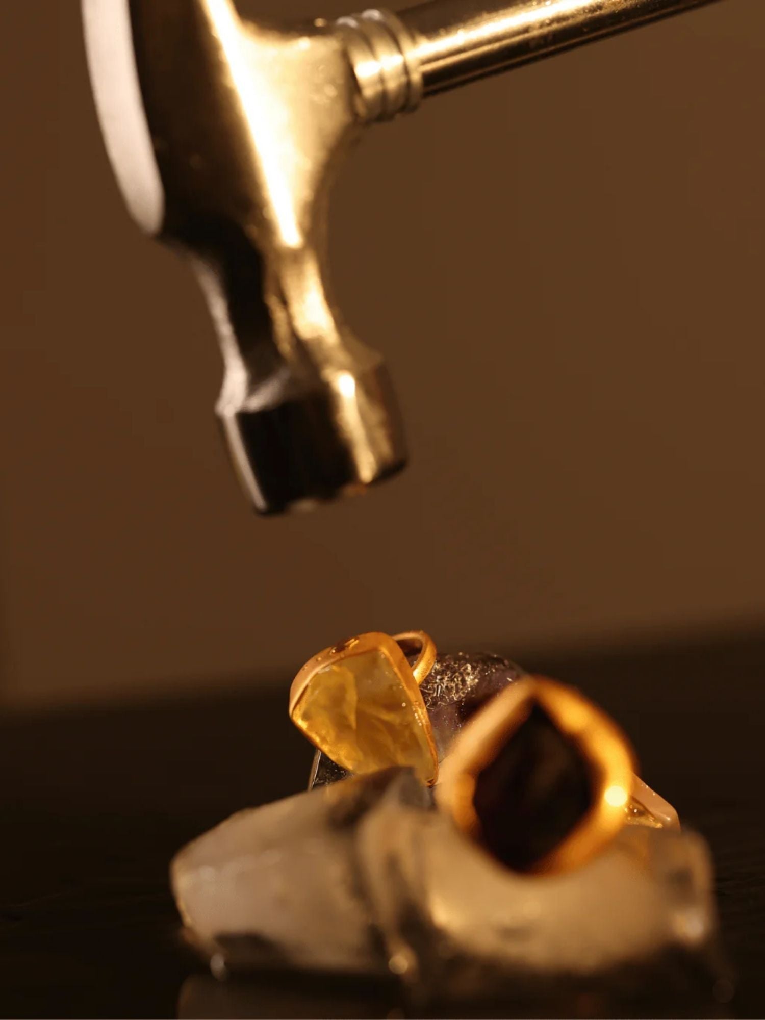 Gold raw citrine ring next to jewellery-making tool, detail process shot