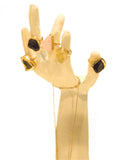 Multiple raw crystal rings in gold displayed on white hand-form prop