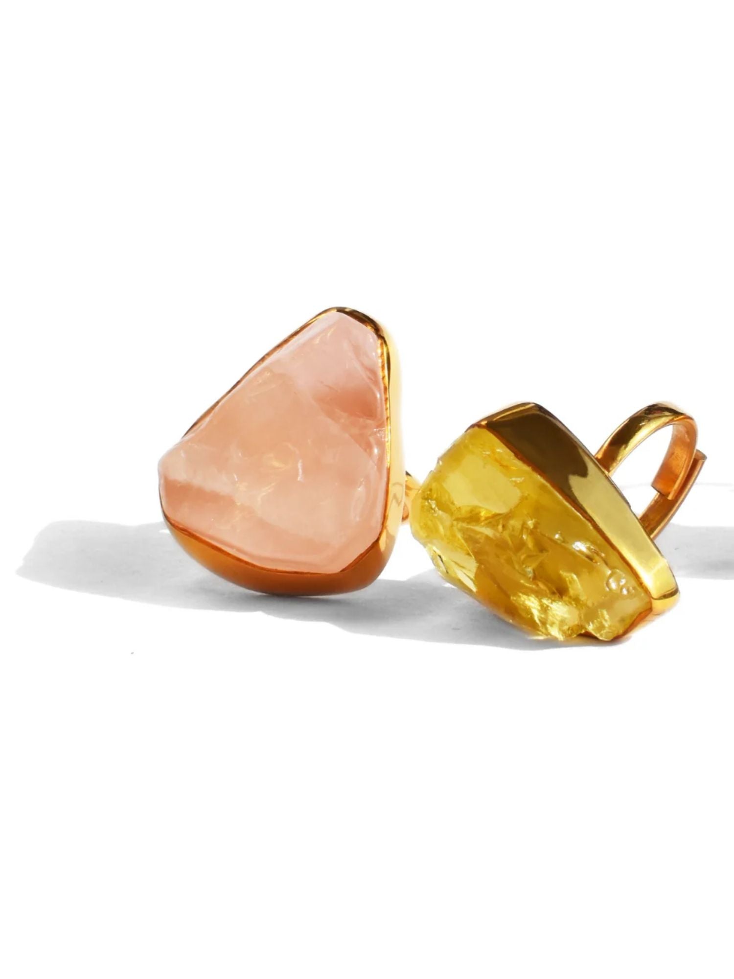 Rose quartz and citrine raw stone cocktail rings in gold setting on white