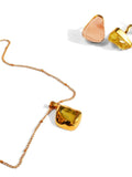 Gold pendant necklace with citrine stone and rose quartz earrings on white