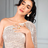 Model in embellished top wearing gold cube earrings, eyes closed