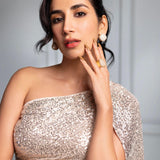 Model wearing gold cube earrings, hand near face in close portrait