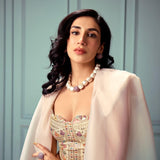 Model wearing brushed gold cube necklace styled with embroidered top