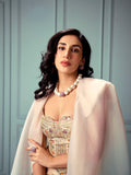 Model wearing brushed gold cube necklace styled with embroidered top