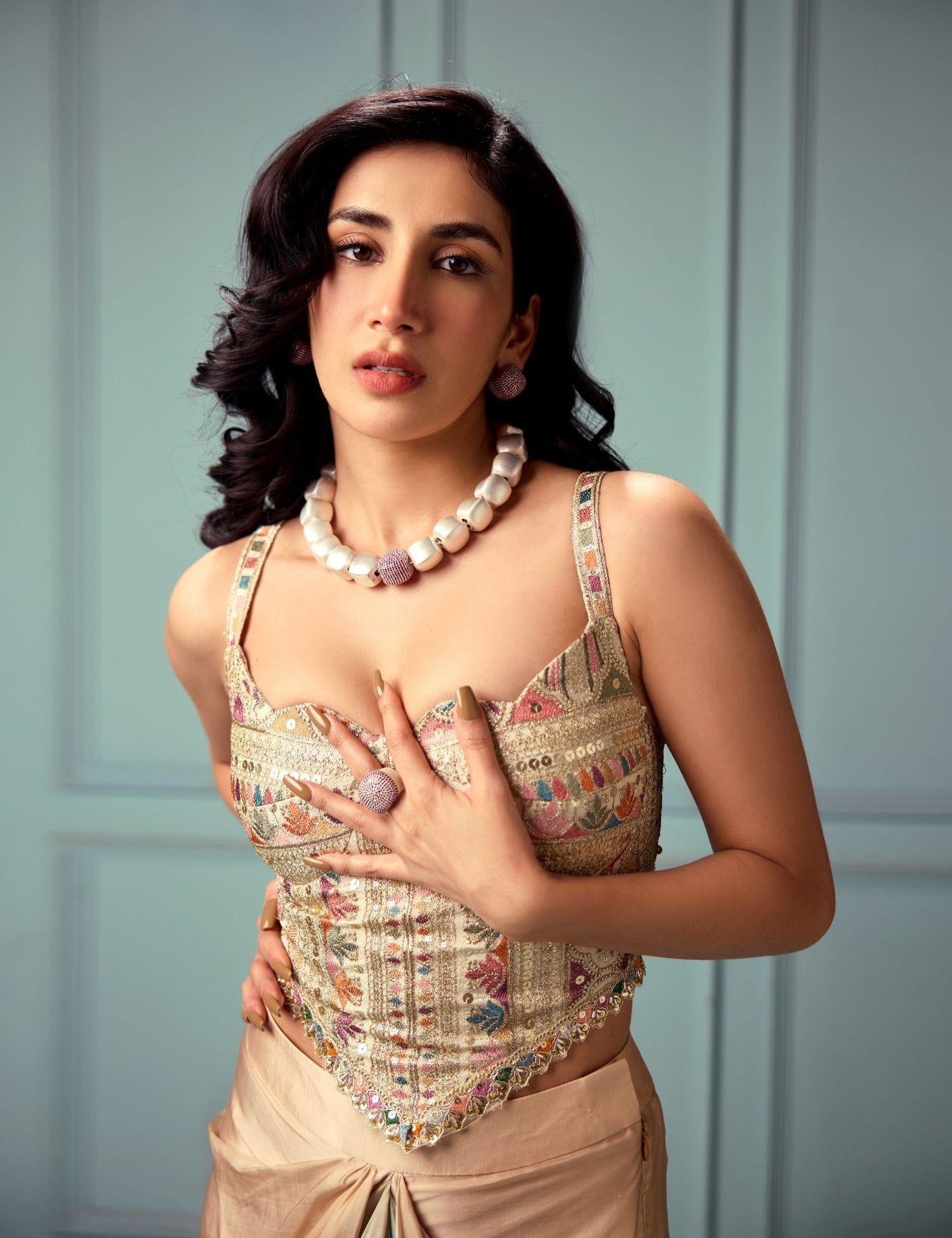 Model in ethnic attire wearing gold CZ dome ring and cube necklace