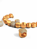 Gold cube necklace and earring set with CZ sphere on white background
