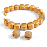 Gold cube necklace and earring set with CZ sphere on white background