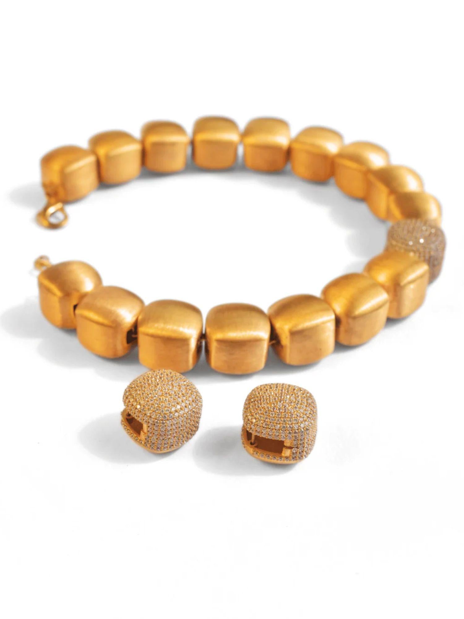 Gold cube necklace and earring set with CZ sphere on white background