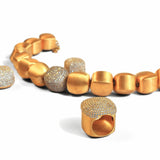 Gold and CZ pave cube necklace with matching dome ring laid flat on white