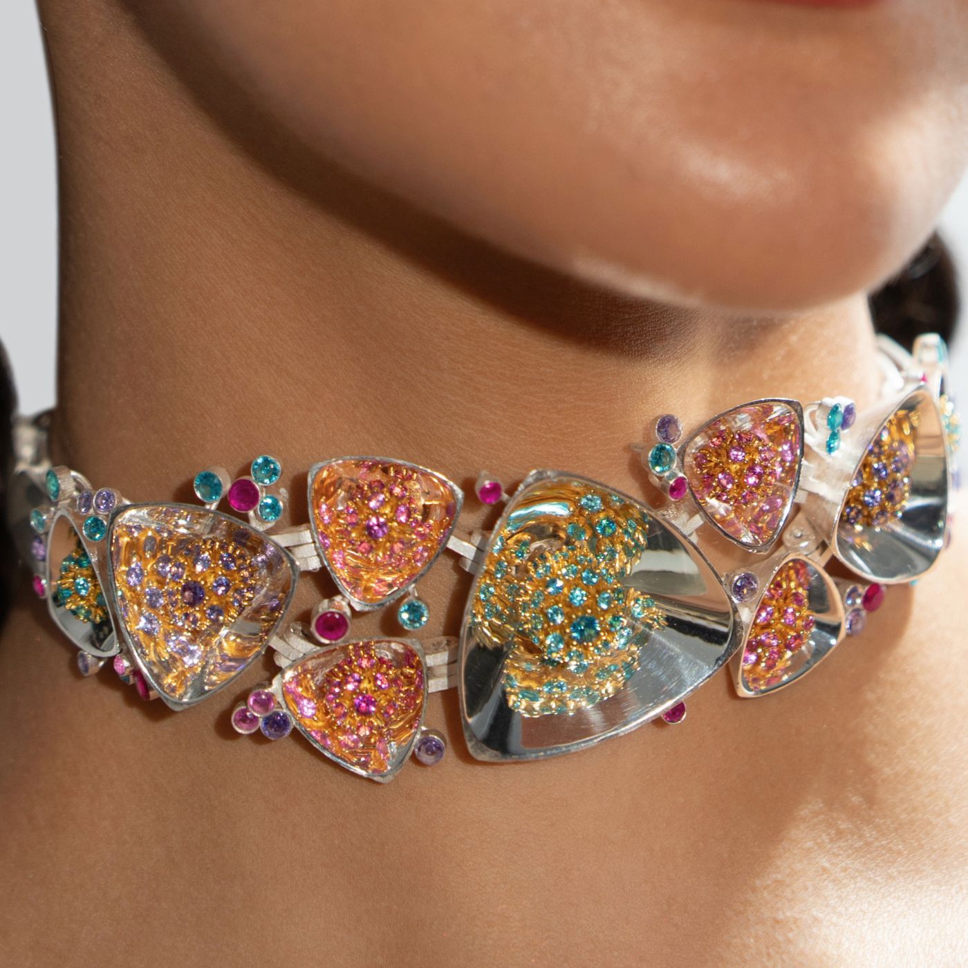 Model wearing sculptural silver Kaleidoscope necklace with multicolour zircon flower motifs